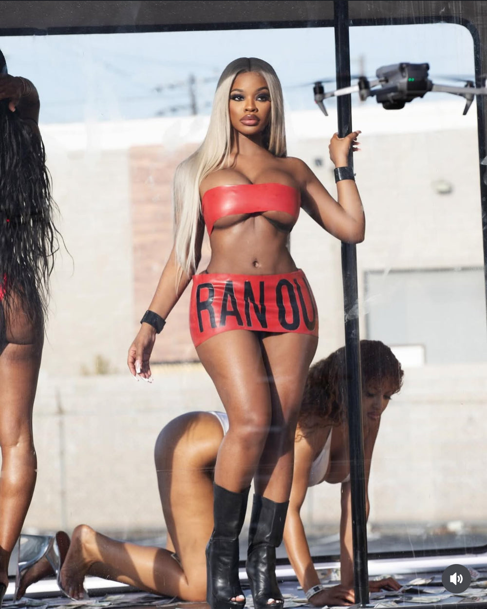 Woman in a red outfit with 'RAN OUT' text, standing outdoors.